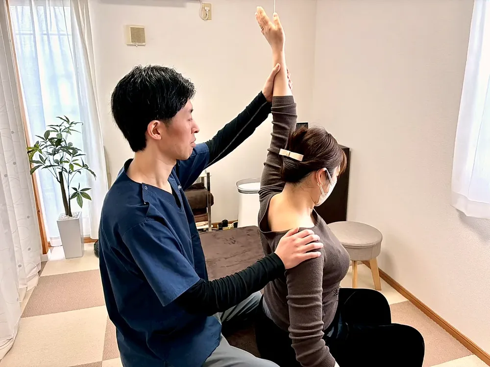 腕を上げてもらいながら、お身体の動きを確認している様子