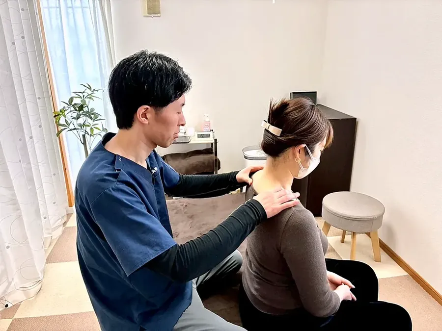 肩に手を当てて施術している様子
