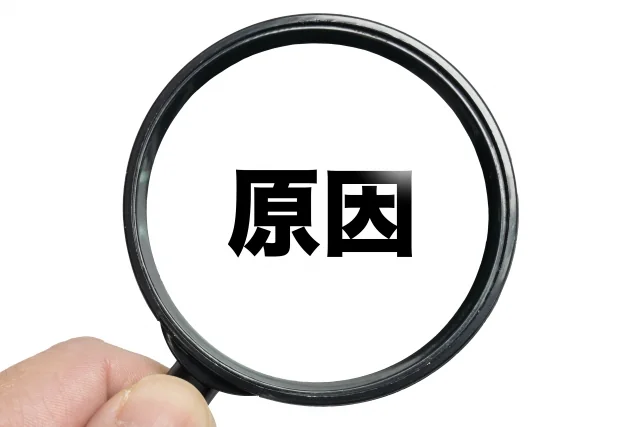 虫めがねで「原因」の文字を見ている様子