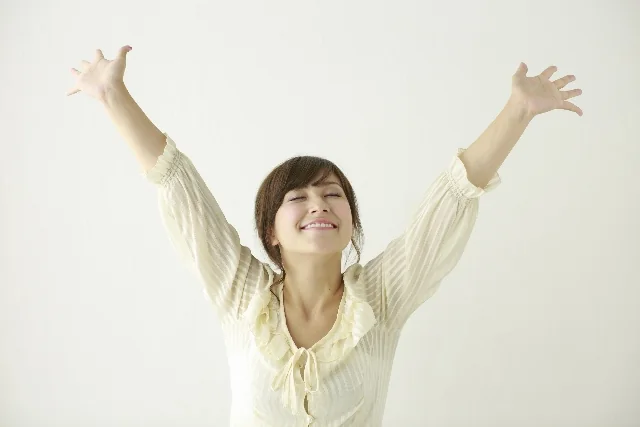 両手を広げてのびのびとしている女性